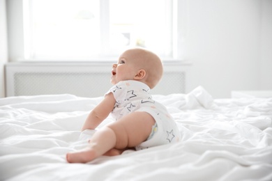 Cute little baby crawling on bed at home