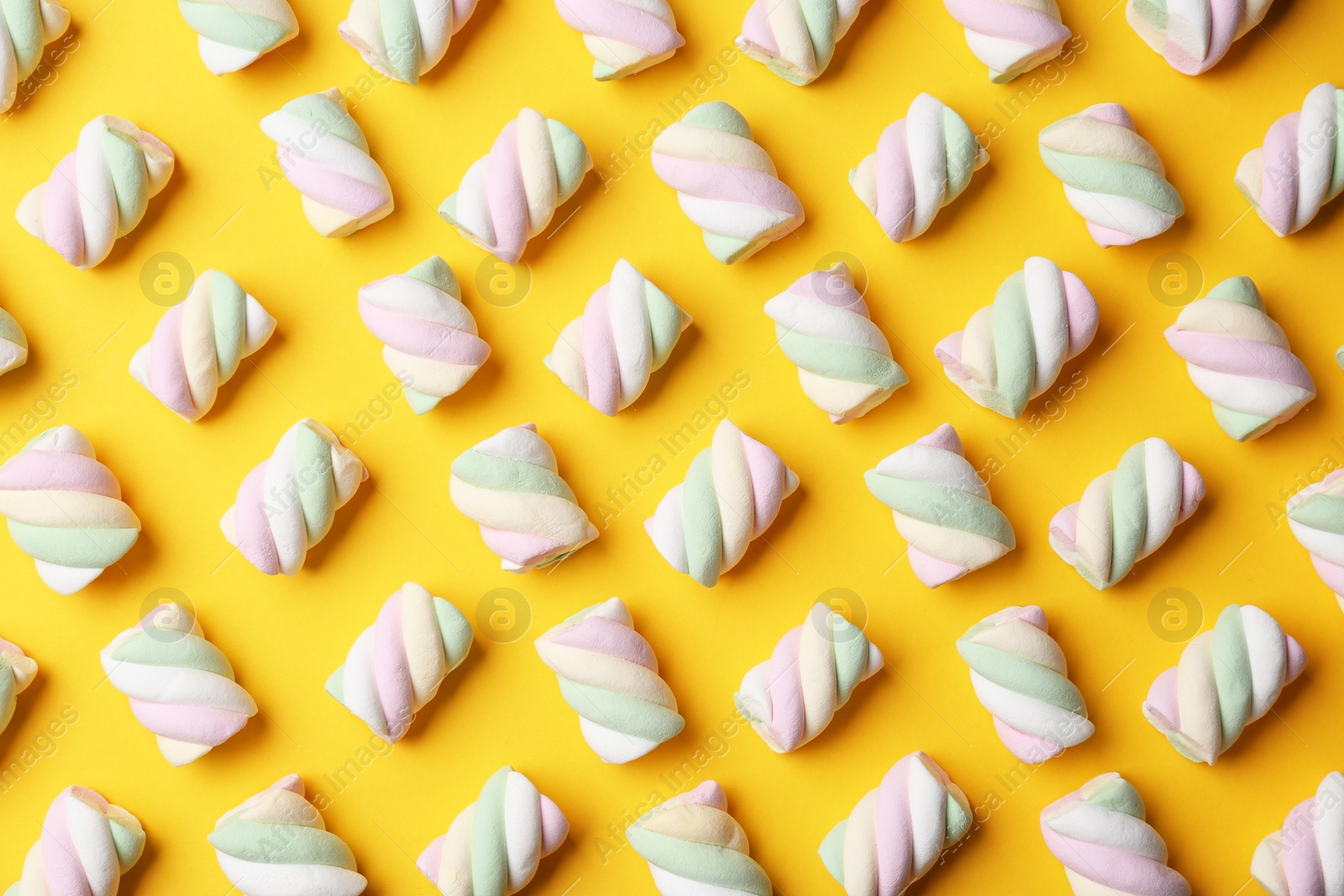 Photo of Delicious colorful marshmallows on yellow background, flat lay