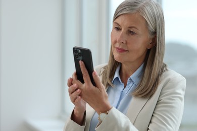 Senior woman using mobile phone at home