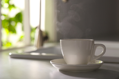 Photo of Cup of delicious coffee on kitchen countertop, space for text. Good morning