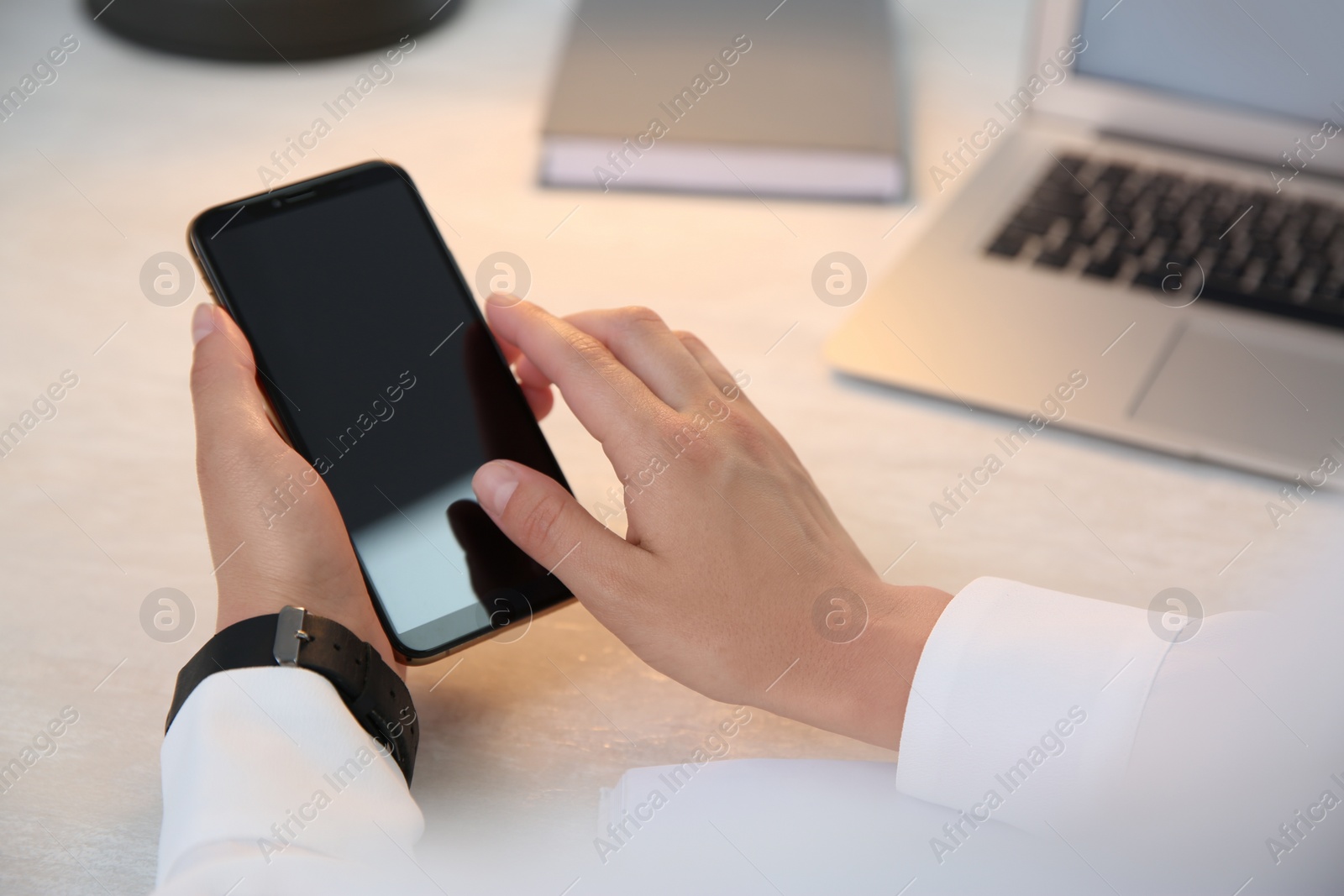 Photo of Woman with modern smartphone at table, closeup. Space for design