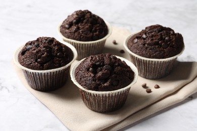 Photo of Tasty chocolate muffins on white table, closeup
