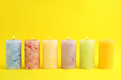 Photo of Alight scented wax candles on color background