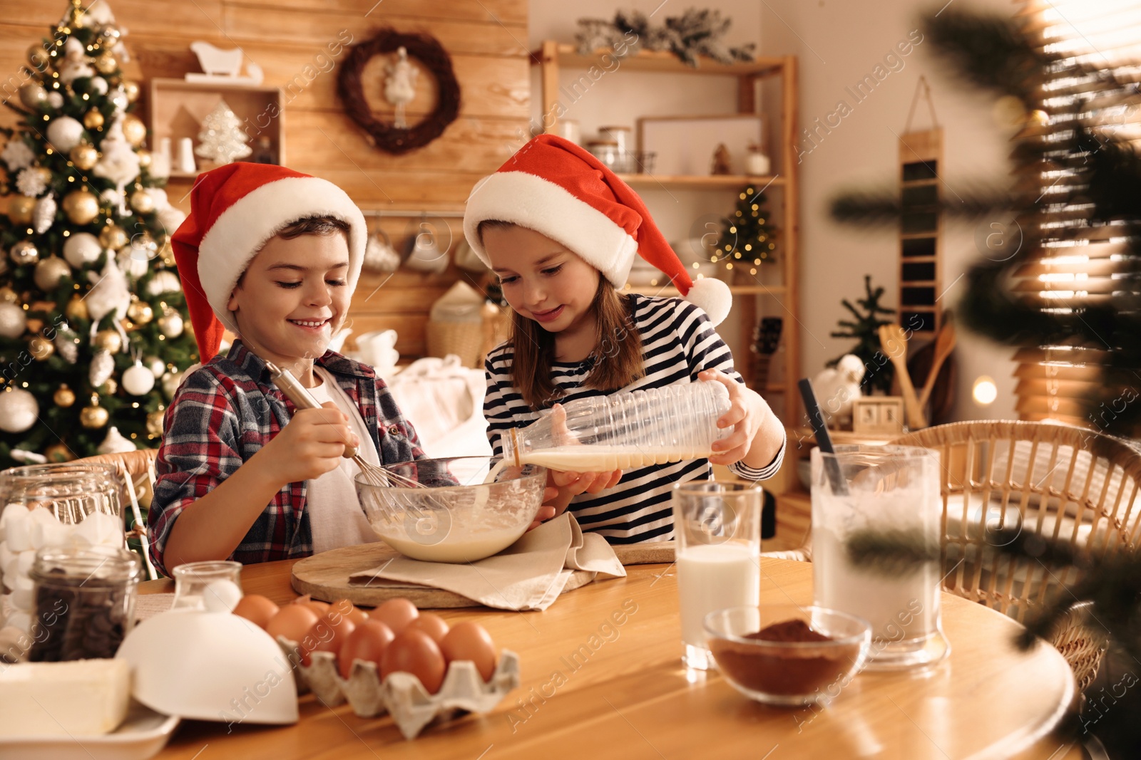 Photo of Cute little children making dough for Christmas cookies at home