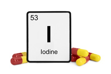 Photo of Card with iodine element and pills isolated on white