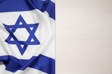 Photo of Flag of Israel on white wooden background, top view and space for text. National symbol