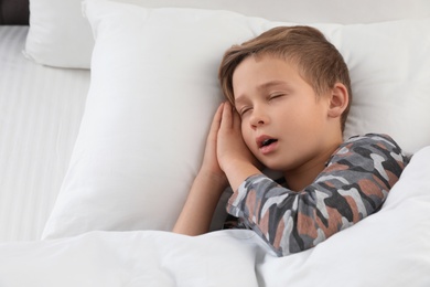 Cute boy sleeping in bed, above view