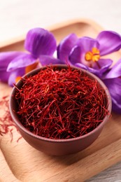 Dried saffron and crocus flowers on wooden tray, closeup