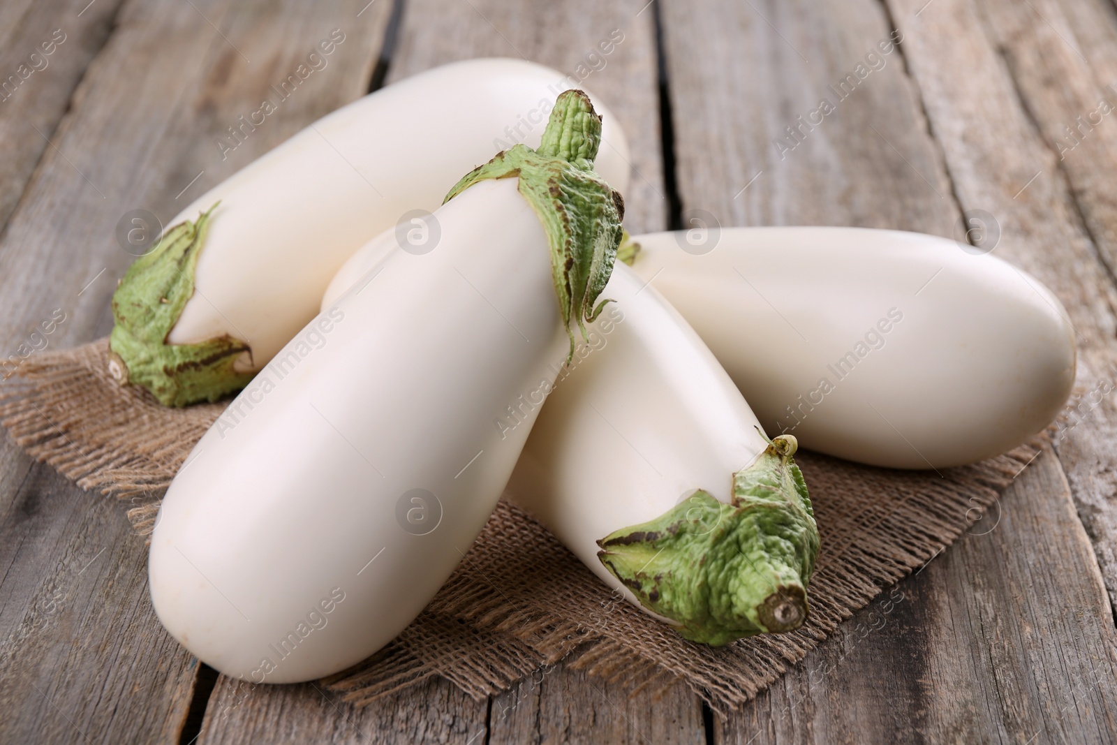 Photo of Pile of fresh white eggplants on wooden table