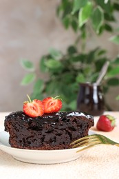 Photo of Piece of chocolate sponge cake with strawberry on beige textured table. Space for text