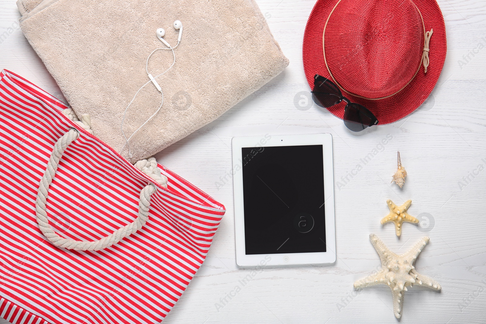 Photo of Flat lay composition with tablet and beach objects on wooden background