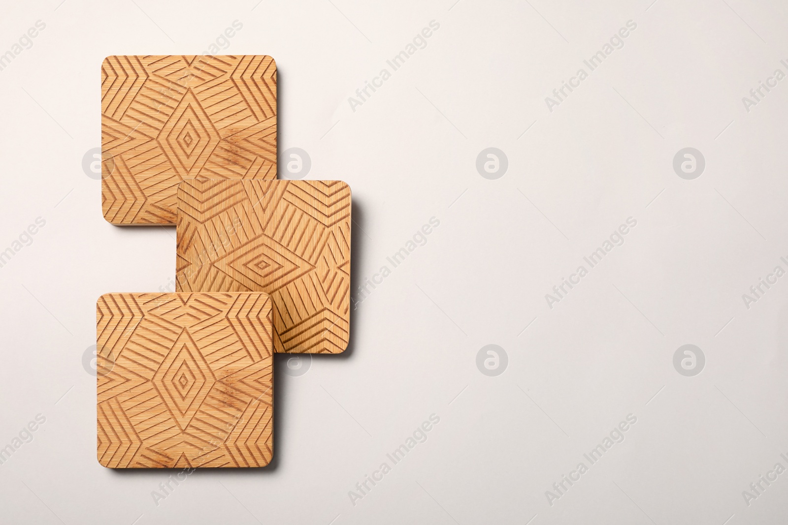 Photo of Stylish wooden cup coasters on white background, flat lay. Space for text