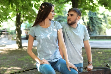 Photo of Young couple wearing gray t-shirts in park