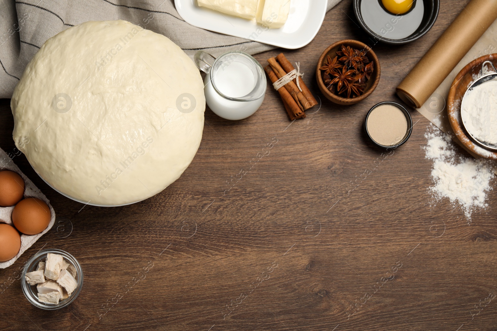 Photo of Flat lay composition with fresh dough and different ingredients on wooden table, space for text. Cooking yeast cake