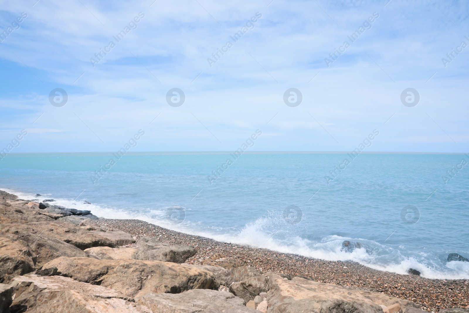 Photo of Picturesque view of foamy waves hitting rocky shore