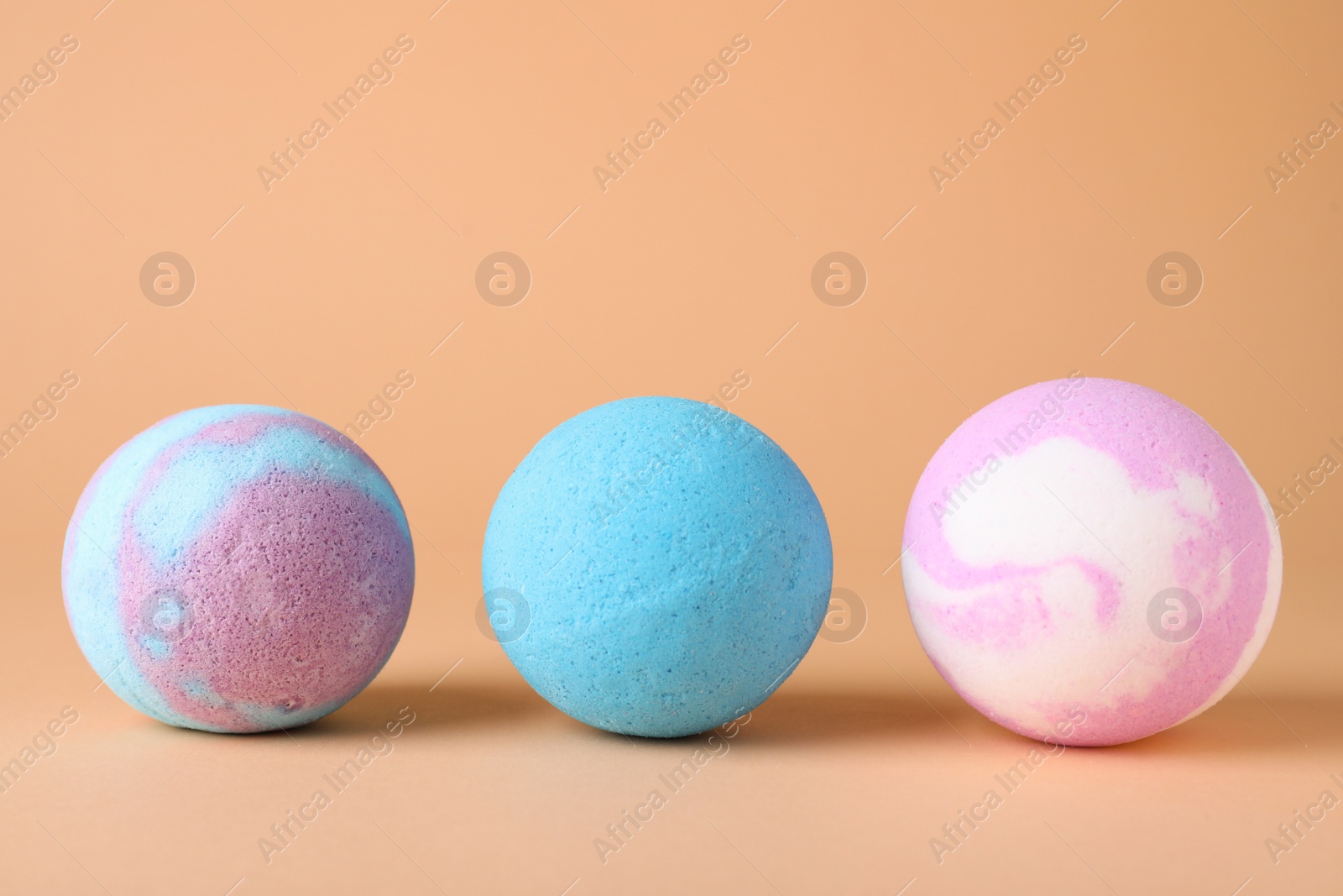 Photo of Different colorful bath bombs on beige background