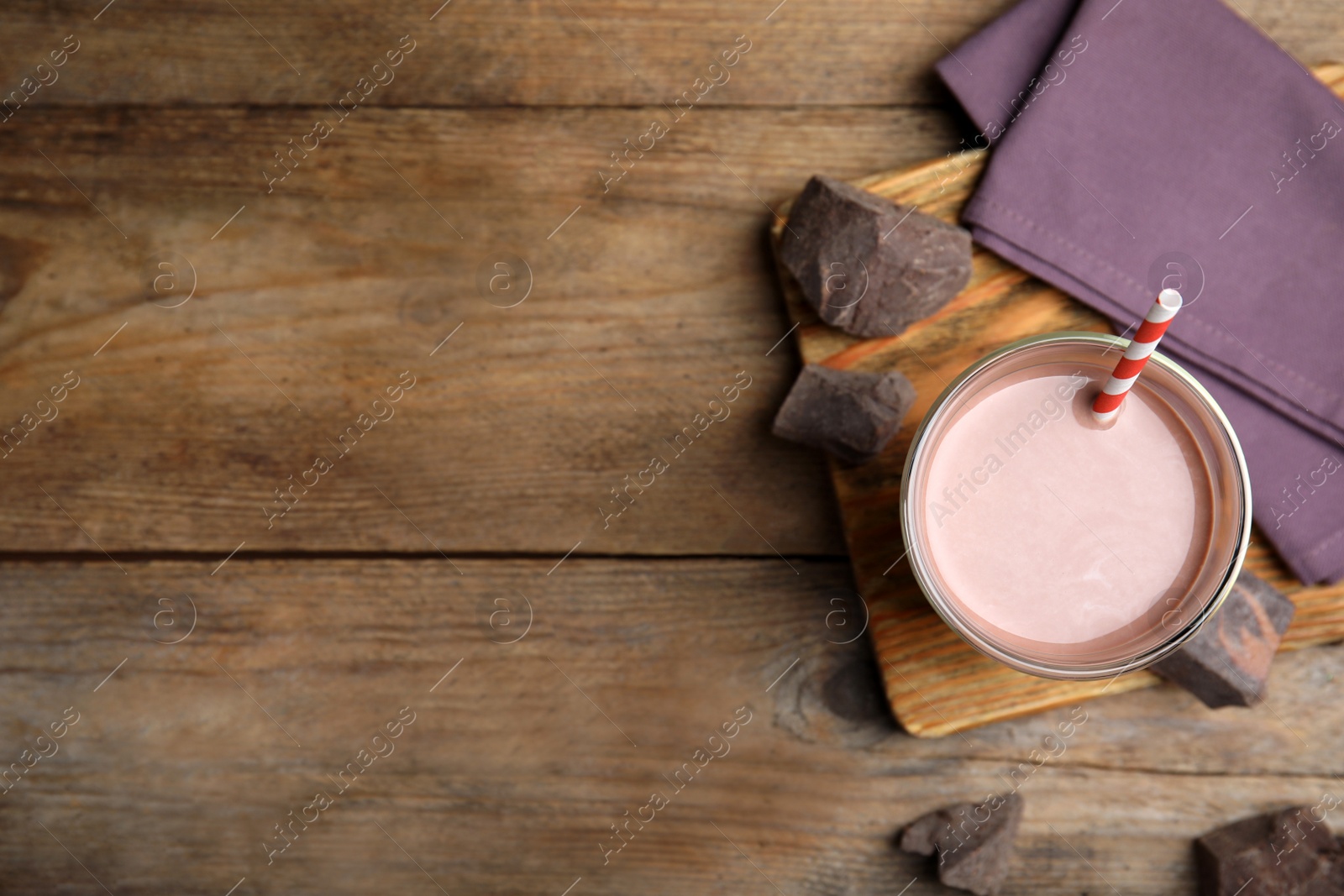 Photo of Delicious chocolate milk on wooden table, flat lay. Space for text