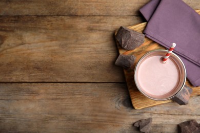 Delicious chocolate milk on wooden table, flat lay. Space for text