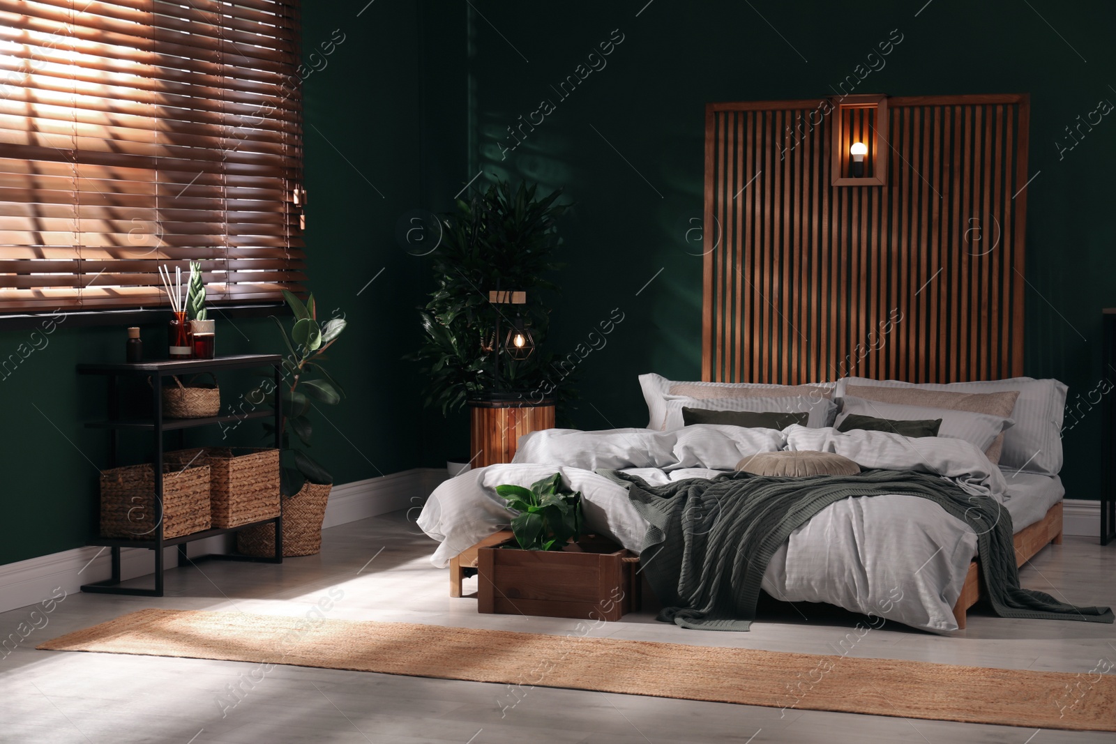 Photo of Stylish interior with large comfortable bed and potted plants