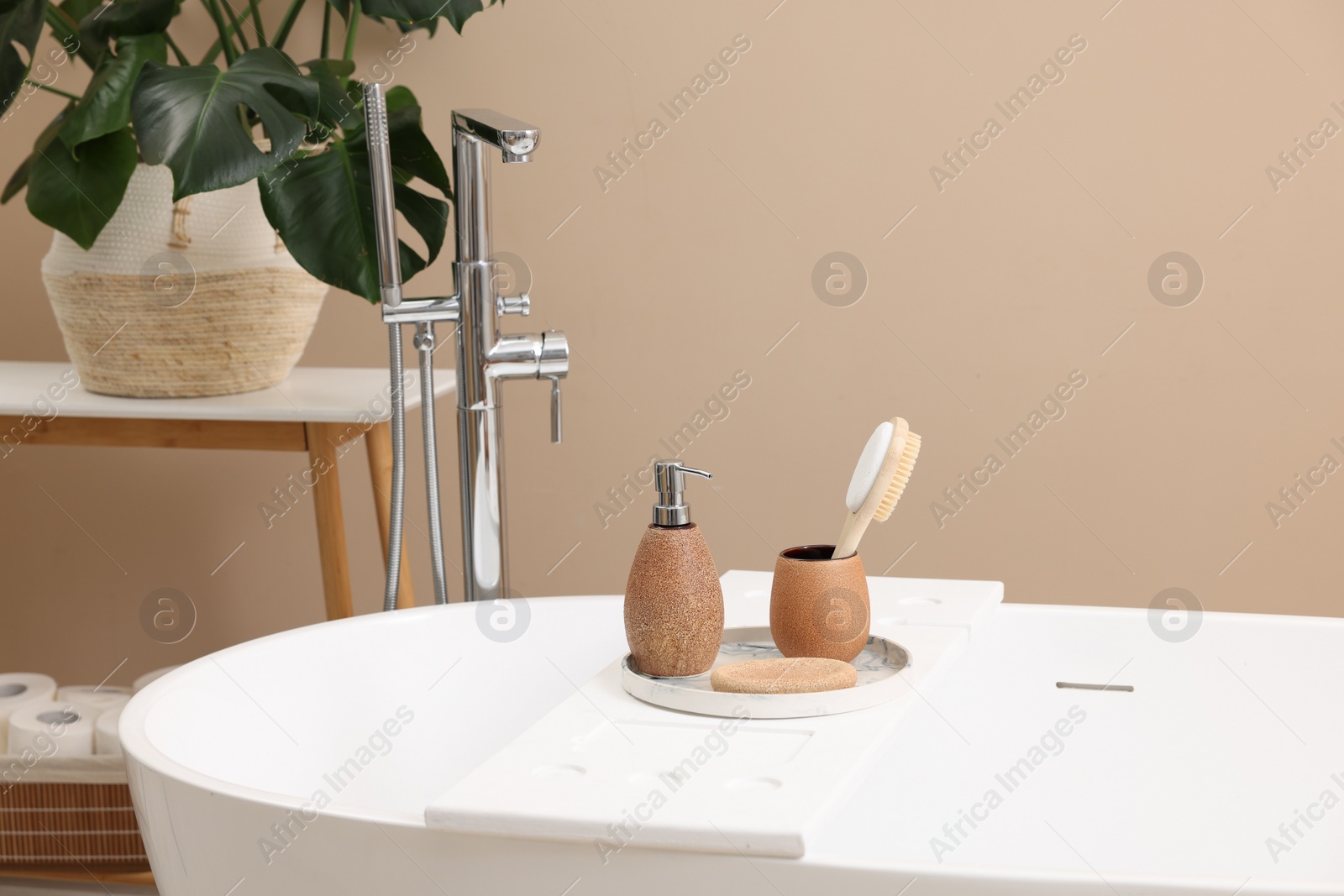 Photo of Different personal care products and accessories on bath tub in bathroom