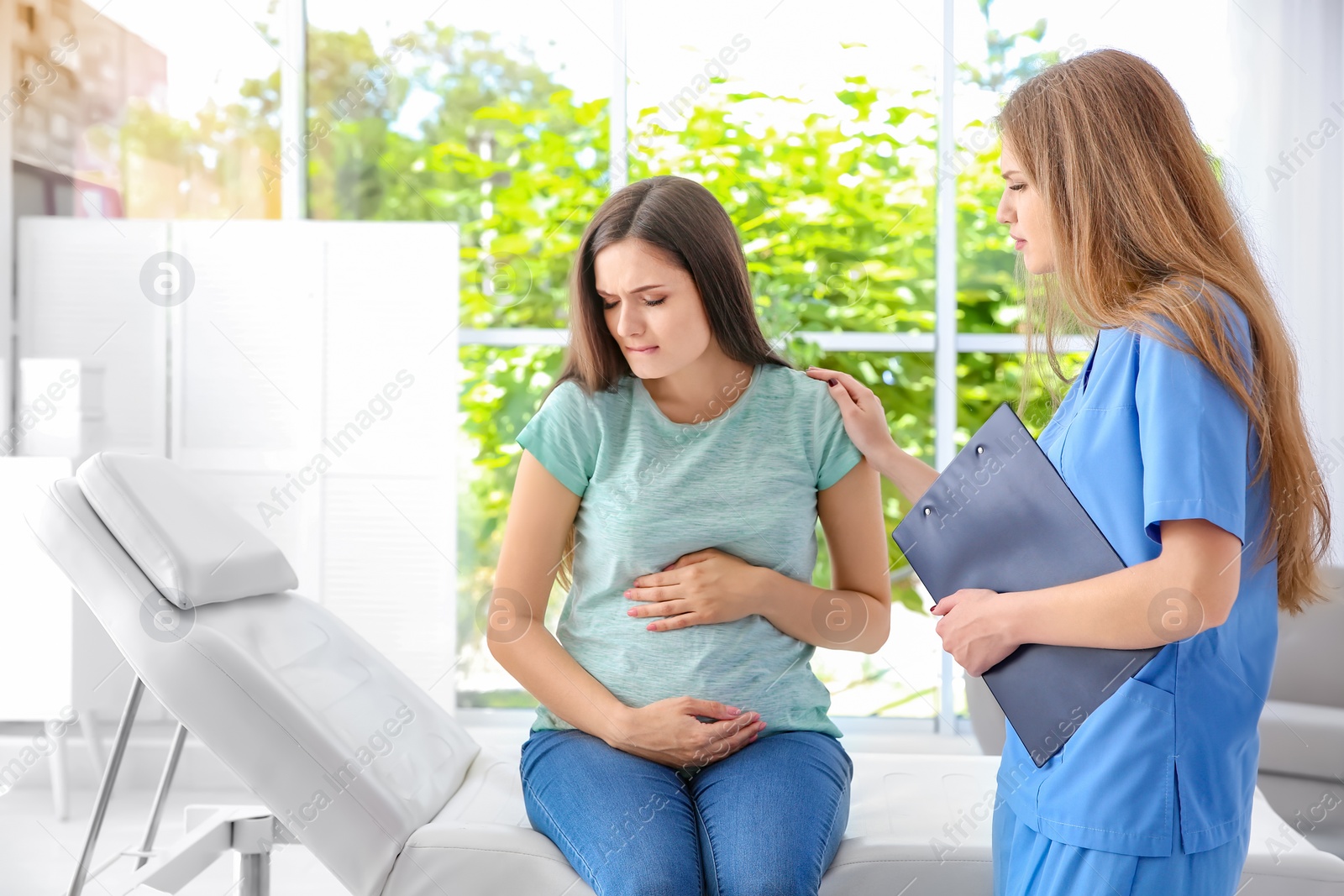 Photo of Young pregnant woman with depression and her doctor in clinic