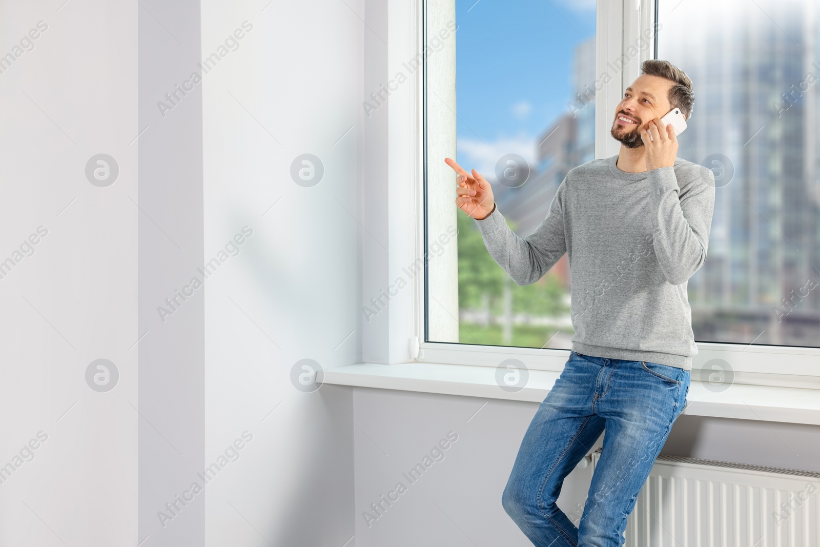 Photo of Man talking on phone near window indoors, space for text