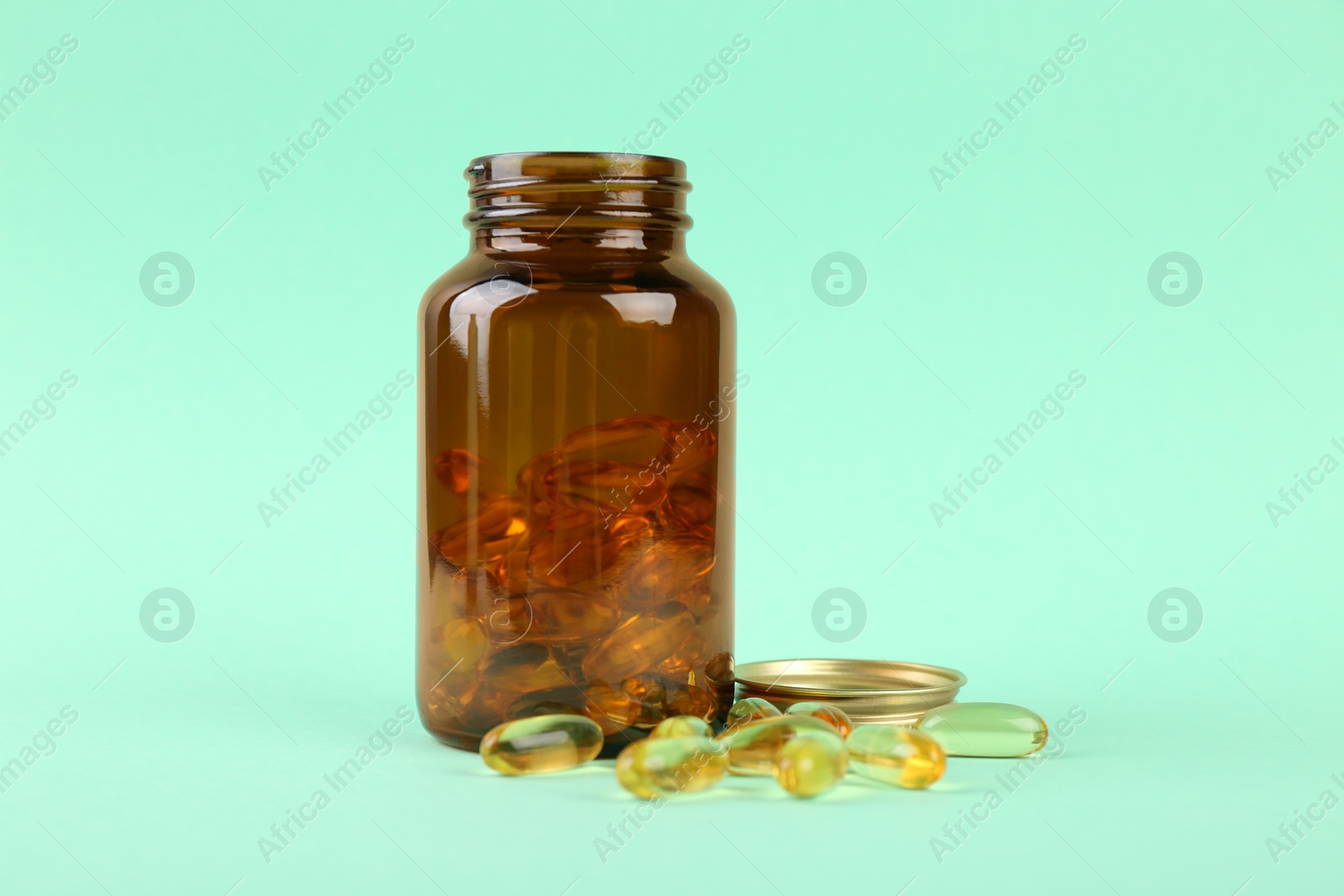 Photo of Jar with vitamin capsules on turquoise background