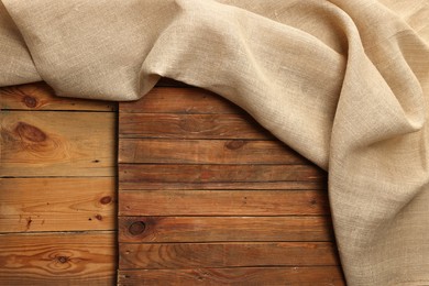 Burlap fabric on wooden table, top view. Space for text