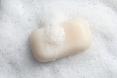 Photo of Soap and fluffy foam on white background, top view