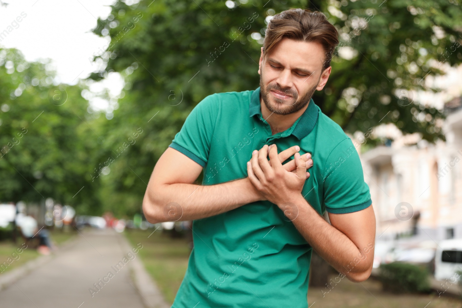 Photo of Young man having heart attack on city street