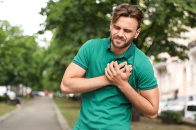 Photo of Young man having heart attack on city street