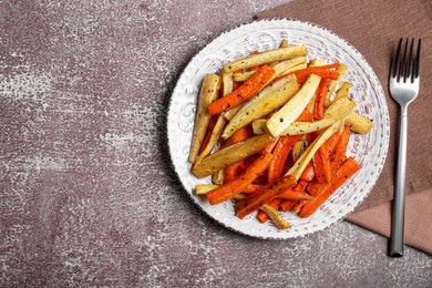 Plate with tasty parsnip and bell pepper served on brown textured table, flat lay. Space for text