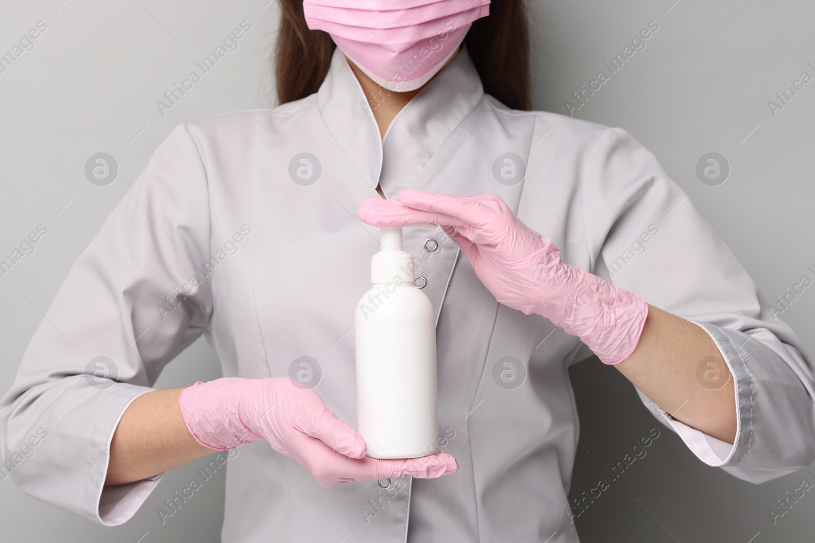 Photo of Cosmetologist with cosmetic product on grey background, closeup