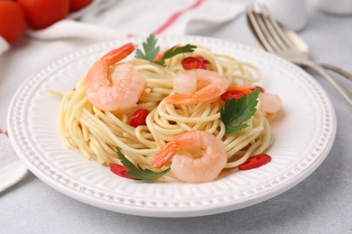 Tasty spaghetti with shrimps, chili pepper and parsley on grey table, closeup