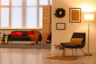 Comfortable furniture in stylish room decorated for Christmas. Interior design