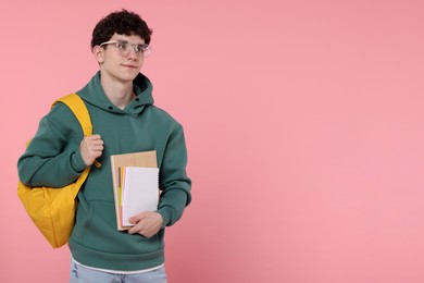 Photo of Portrait of student with backpack and notebooks on pink background. Space for text