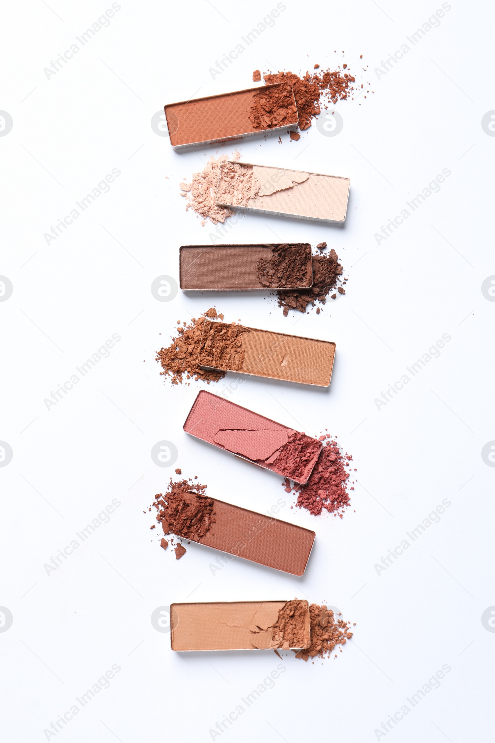 Photo of Different crushed eye shadows on white background, flat lay. Professional makeup product