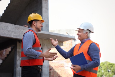 Professional engineers in safety equipment at construction site