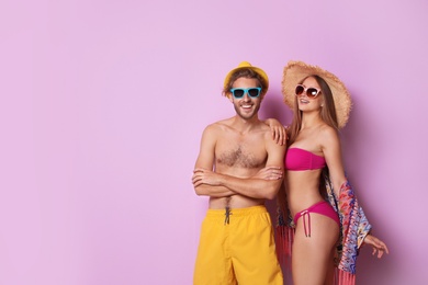 Photo of Happy young couple in beachwear on color background. Space for text