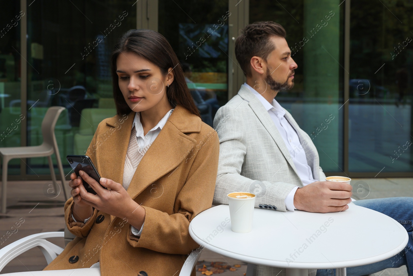 Photo of Upset arguing couple in outdoor cafe. Relationship problems