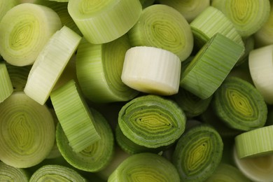 Photo of Fresh raw leek slices as background, top view