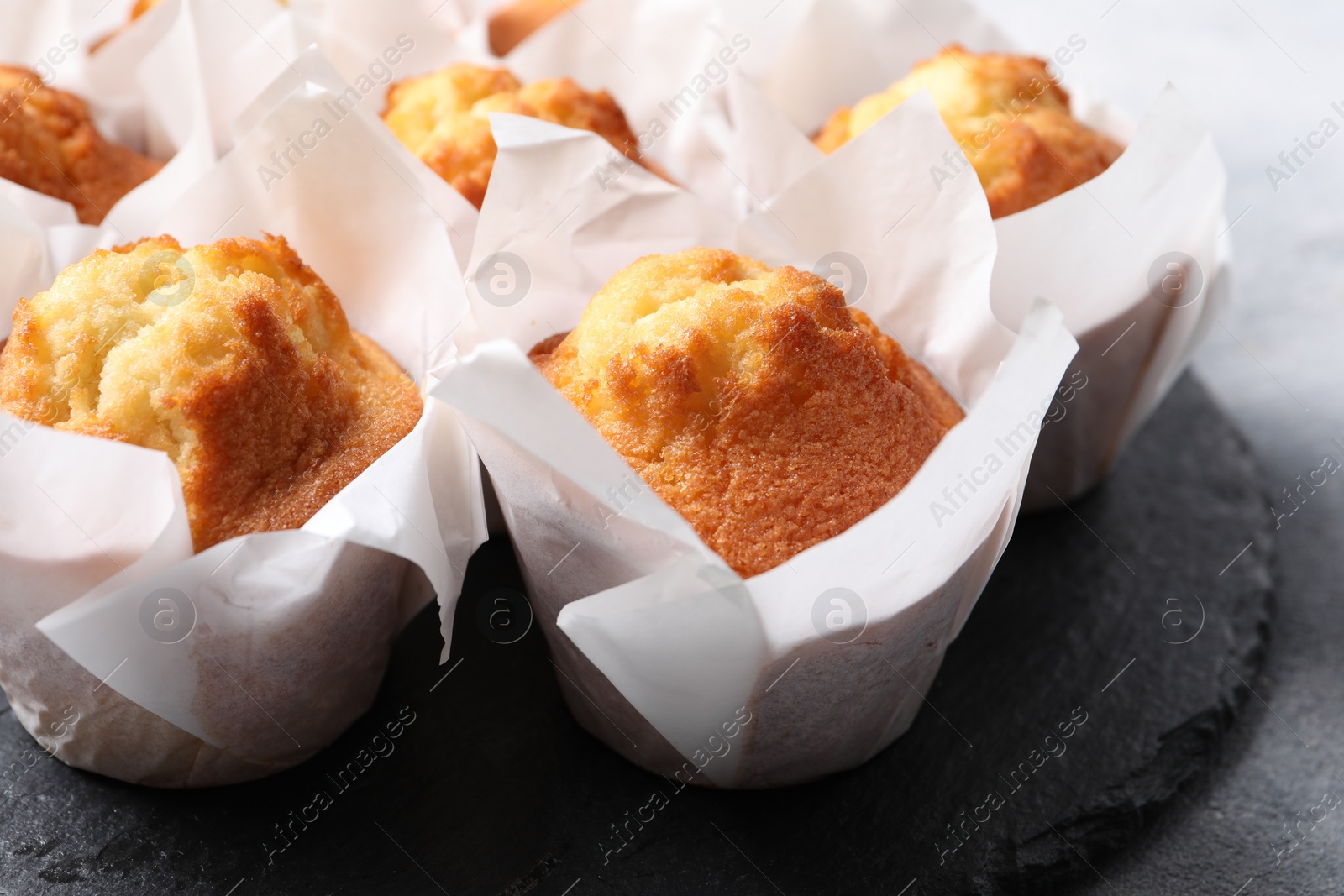 Photo of Delicious sweet muffins on grey table, closeup