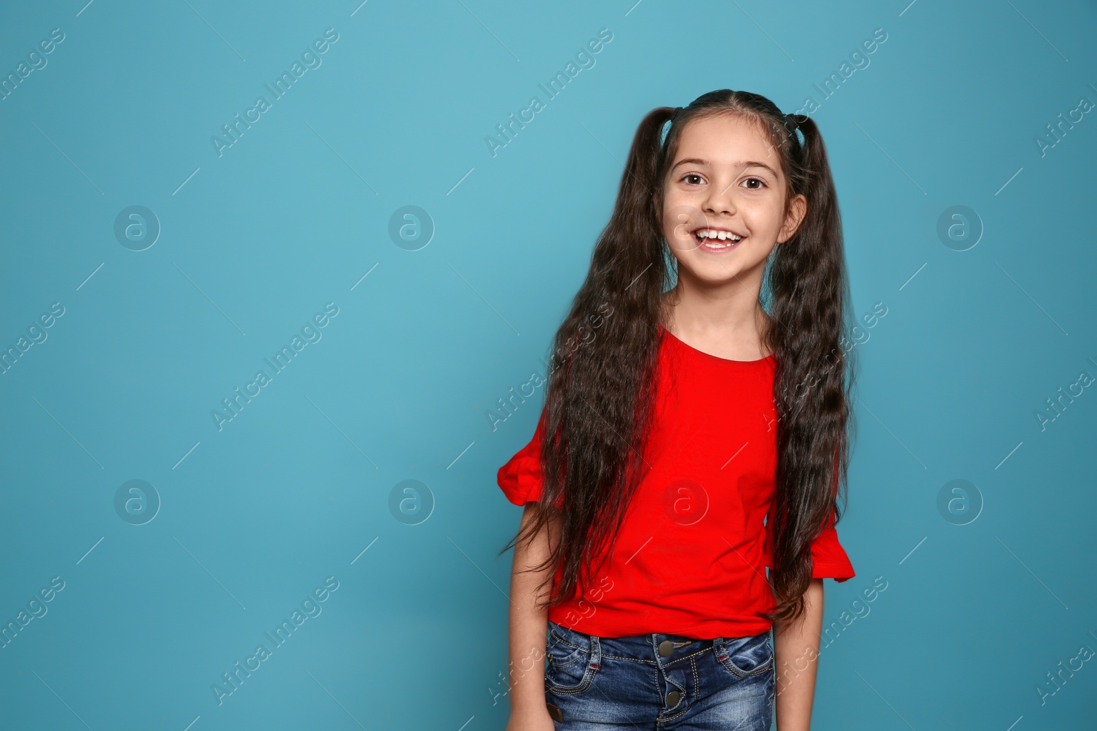 Photo of Portrait of little girl laughing on color background. Space for text