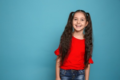 Photo of Portrait of little girl laughing on color background. Space for text