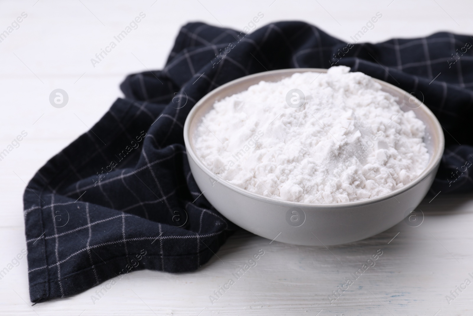 Photo of Starch in bowl on white wooden table, closeup