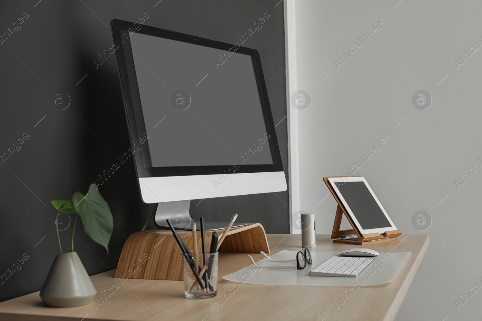 Photo of Modern workplace interior with computer on table. Space for text