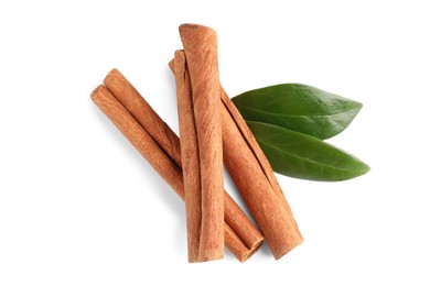 Cinnamon sticks and green leaves isolated on white, top view