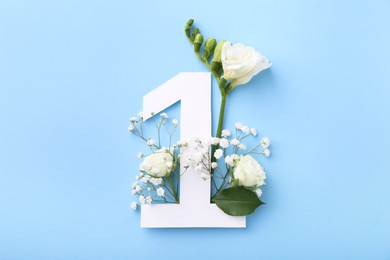 Paper number 1 and beautiful flowers on light blue background, top view