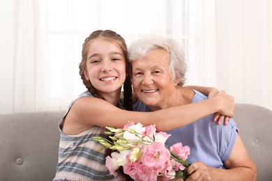 Happy girl congratulating her grandmother at home