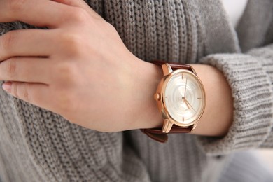 Woman in casual sweater with luxury wristwatch, closeup